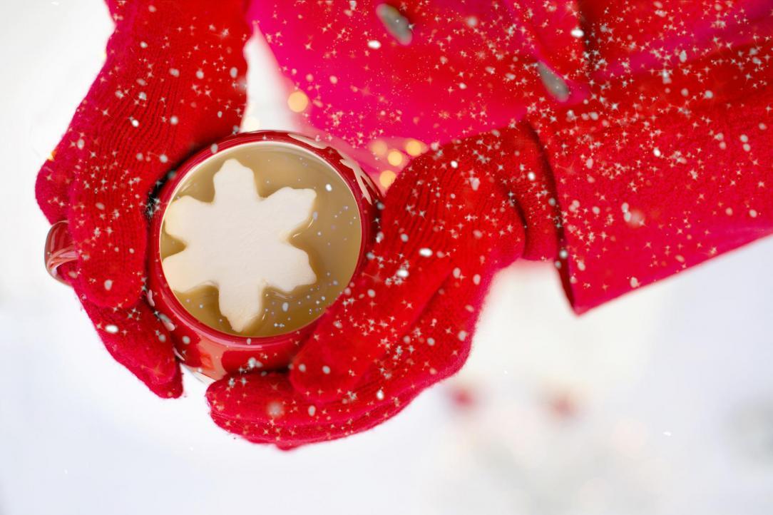 Overhead view of a cup of hot chocolate with a snowflake shaped marshmellow floating on top